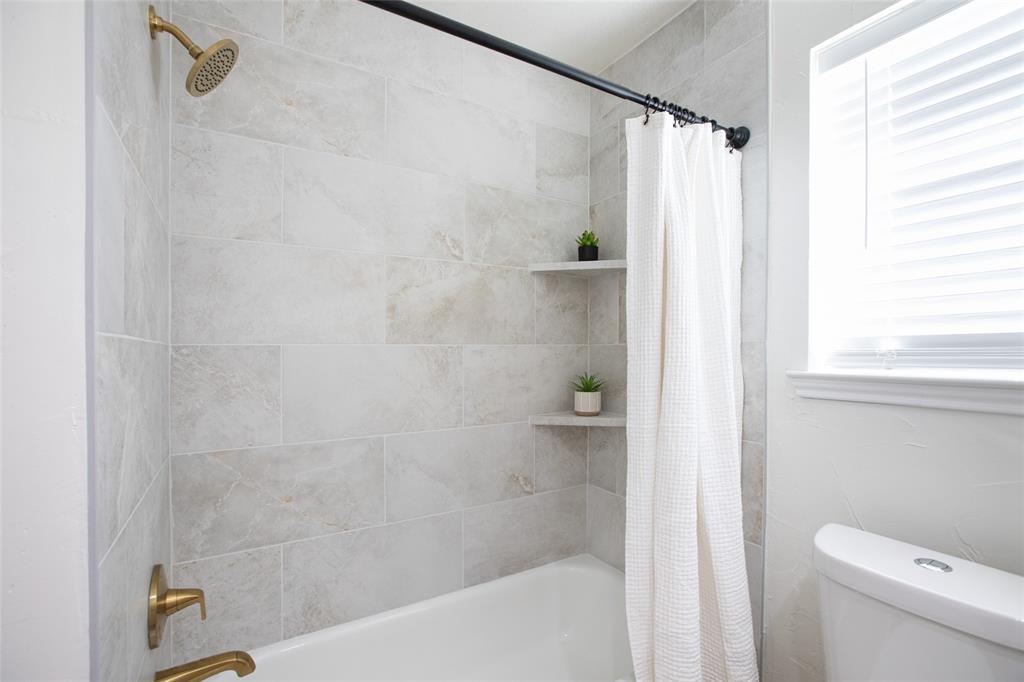 Newly tiled bathtub surround and gold faucets