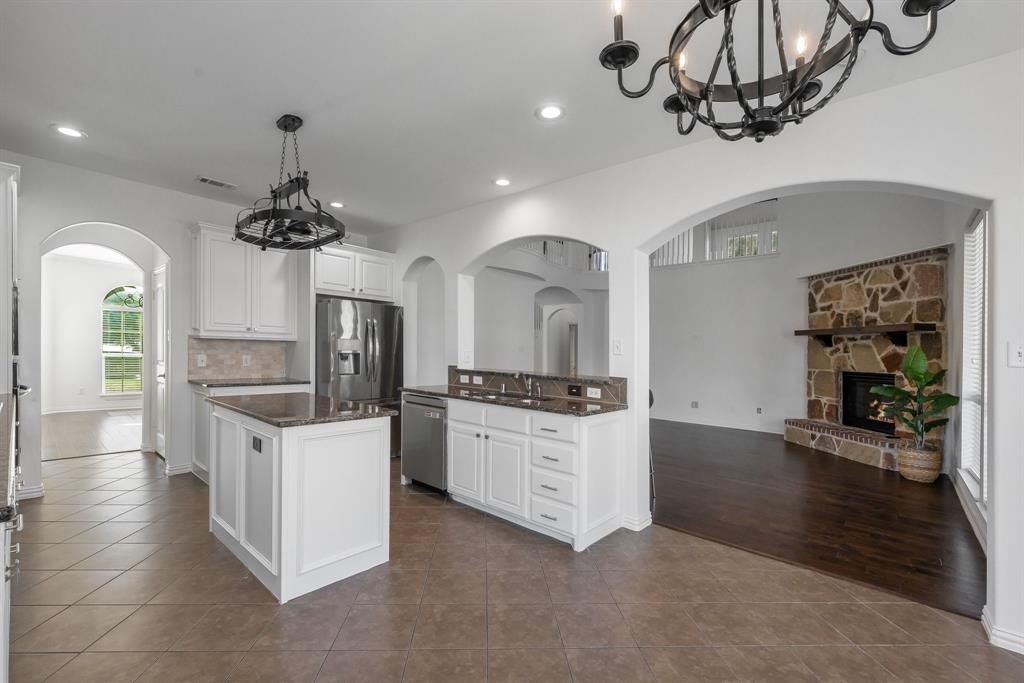 Kitchen featuring white cabinetry, a central island, and stainless steel appliances