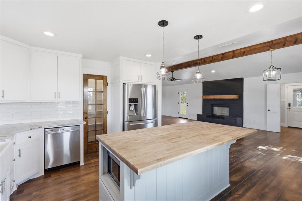 beautiful stone countertops with a glass pantry door and butcher block island