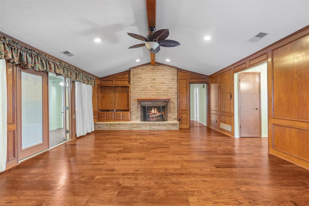 Spacious living room featuring elegant paneling and engineered wood flooring