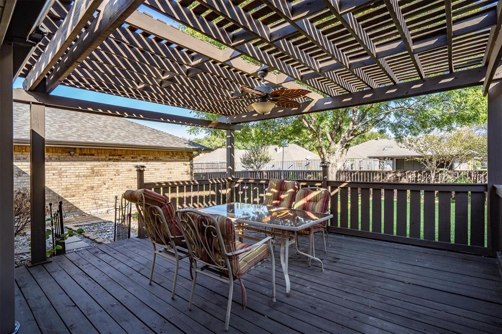 Expansive wooden deck with a shade pergola, perfect for outdoor dining and relaxation