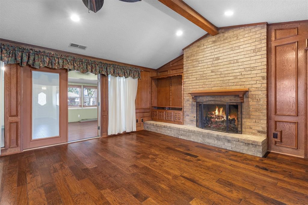 Gather around the brick fireplace in this spacious living room, featuring built-in cabinetry