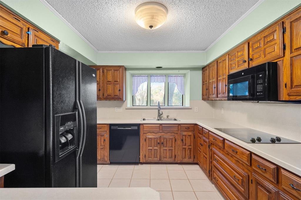 Functional kitchen featuring matching black appliances, cooktop, and generous cabinet storage