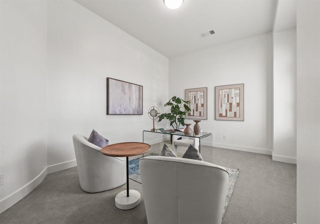 Interior room featuring high ceilings, neutral wall tones, and neutral-toned wall-to-wall carpeting
