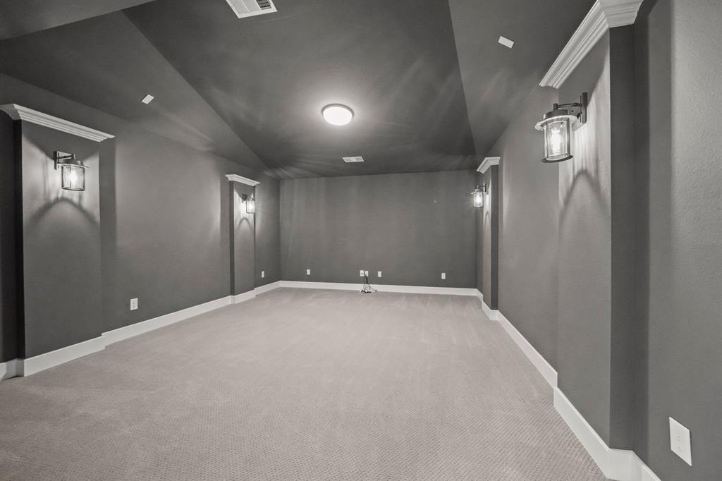 Vaulted ceilings featuring recessed lighting, wall-mounted lantern-style sconces, and crown molding