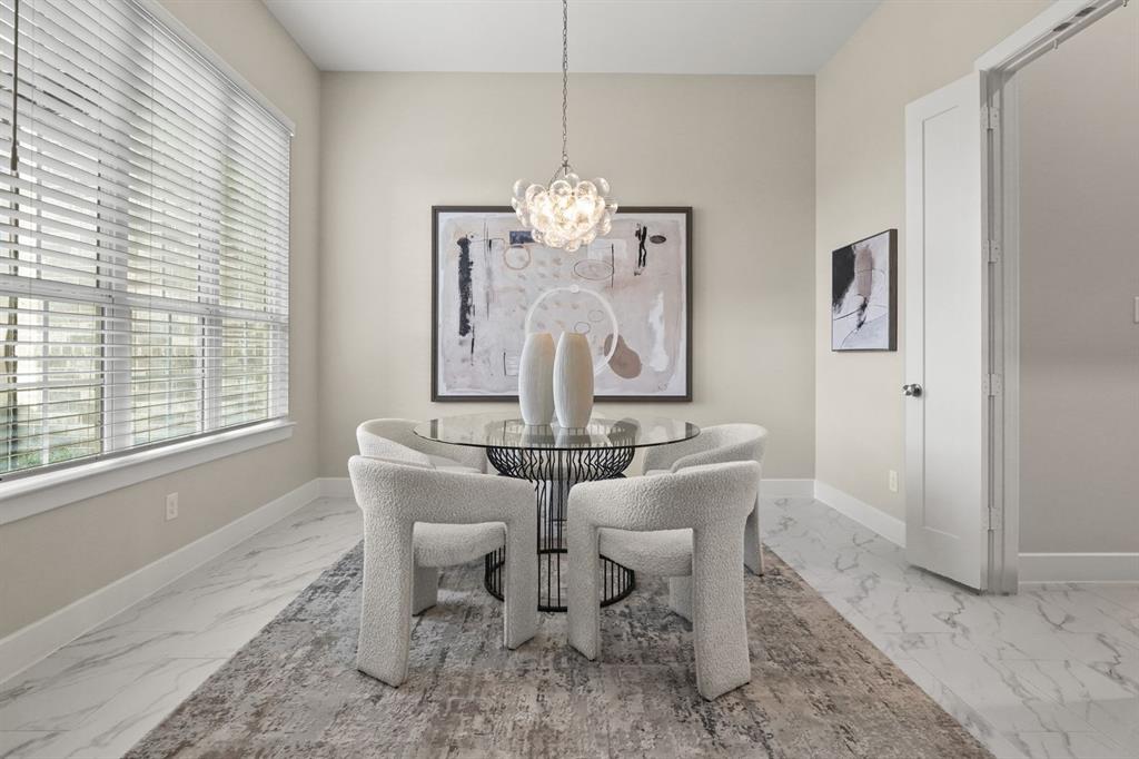 Light-filled room featuring large windows, stone-finish tile flooring, and a decorative multi-bulb pendant chandelier
