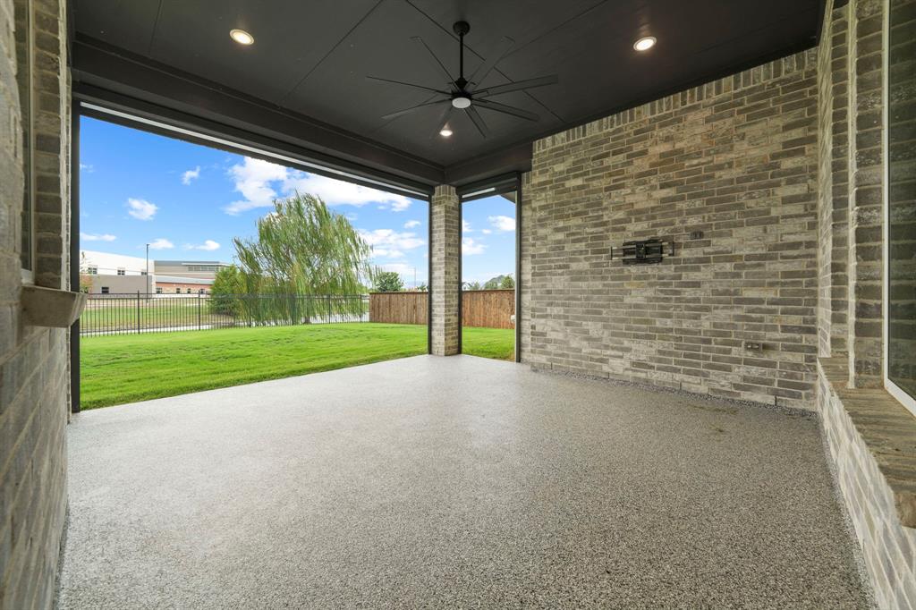 Covered patio featuring an exposed brick wall, recessed lighting, ceiling fan, and finished concrete flooring