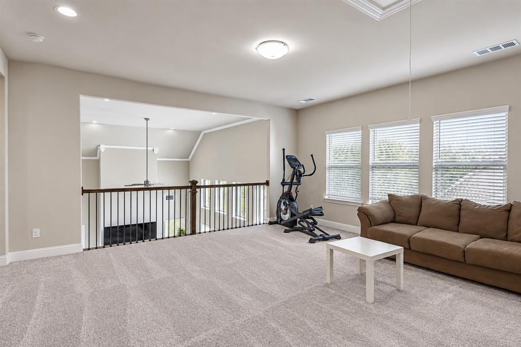 Carpeted open loft space with recessed lighting and a ceiling-mounted light fixture