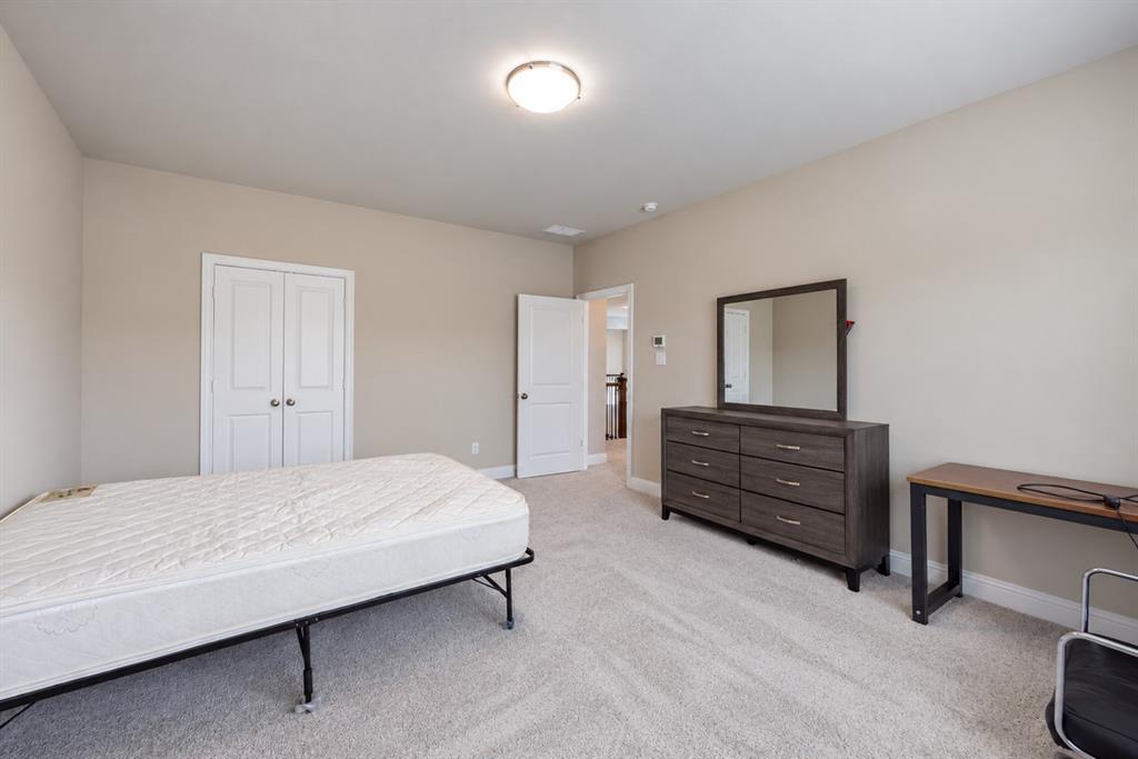 Neutral tone wall paint, light-colored carpeting, white trim, and a flush mount ceiling light fixture