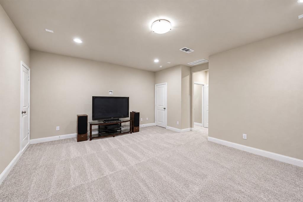 Spacious room with light-colored carpet, recessed lighting, and a ceiling-mounted light fixture