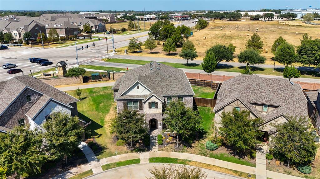 Gabled roofline, stone and siding exterior, front landscaping, concrete walkway, and paved driveway