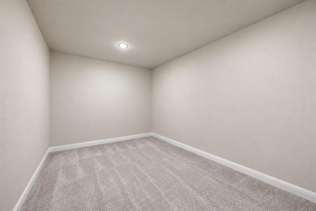Recessed ceiling light, light-toned wall finish, and gray carpet flooring