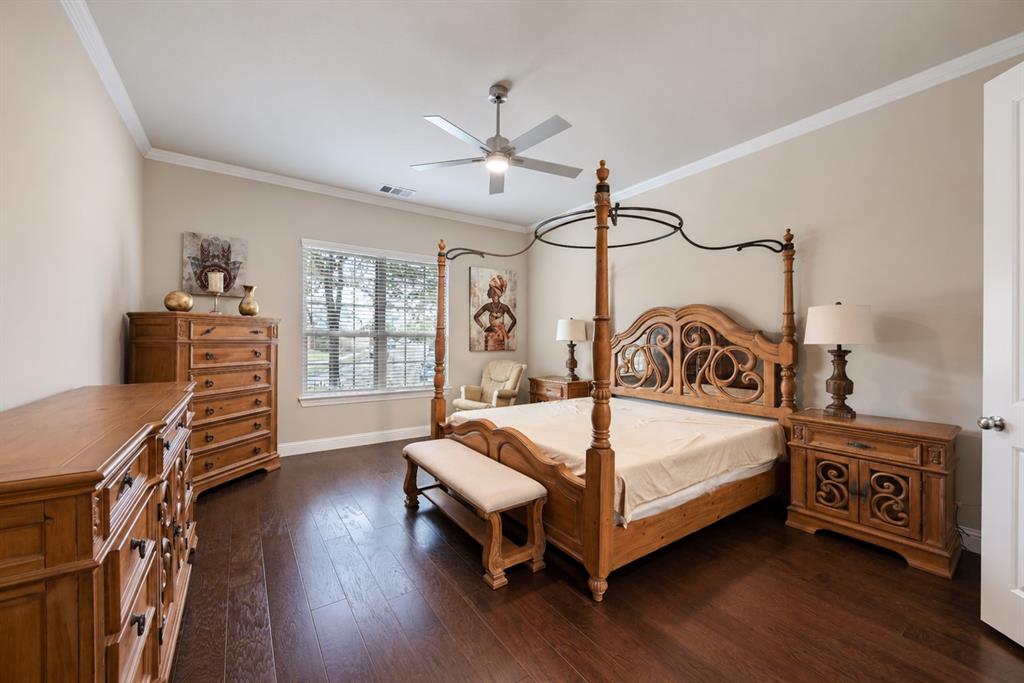 Hardwood-style flooring throughout, crown molding, a ceiling fan with integrated lighting, and a window with blinds
