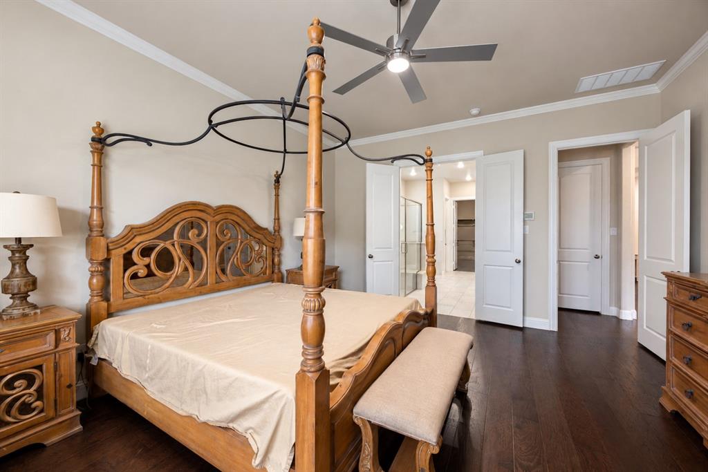 Dark wood-finish flooring, crown molding, and a ceiling fan with integrated lighting