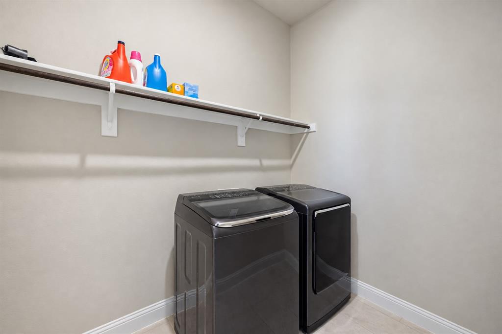 Laundry area featuring a built-in shelf and clothing rod