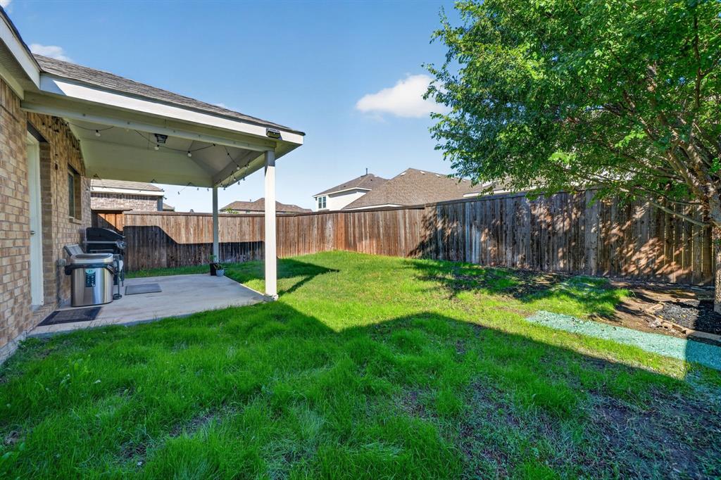 Covered patio with string lighting, concrete flooring, and a full privacy fence