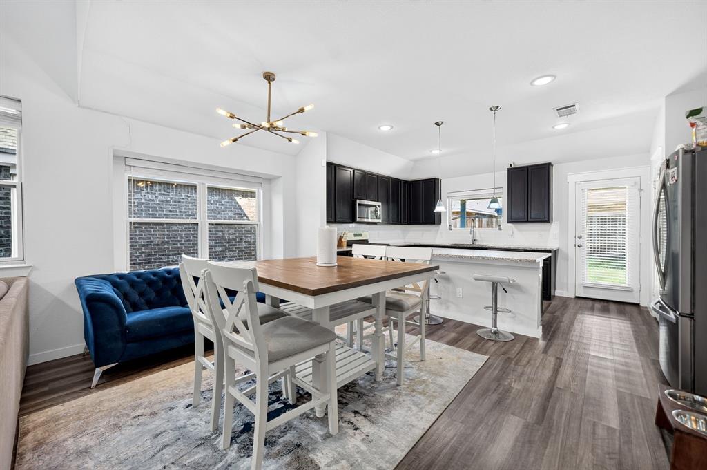 Open-concept living space with wood-finish flooring, a contemporary chandelier, and recessed lighting