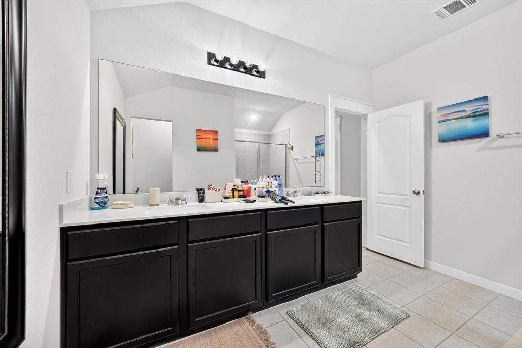 Dual vanity with white countertop, dark wood-finish cabinetry, and a large wall-mounted mirror