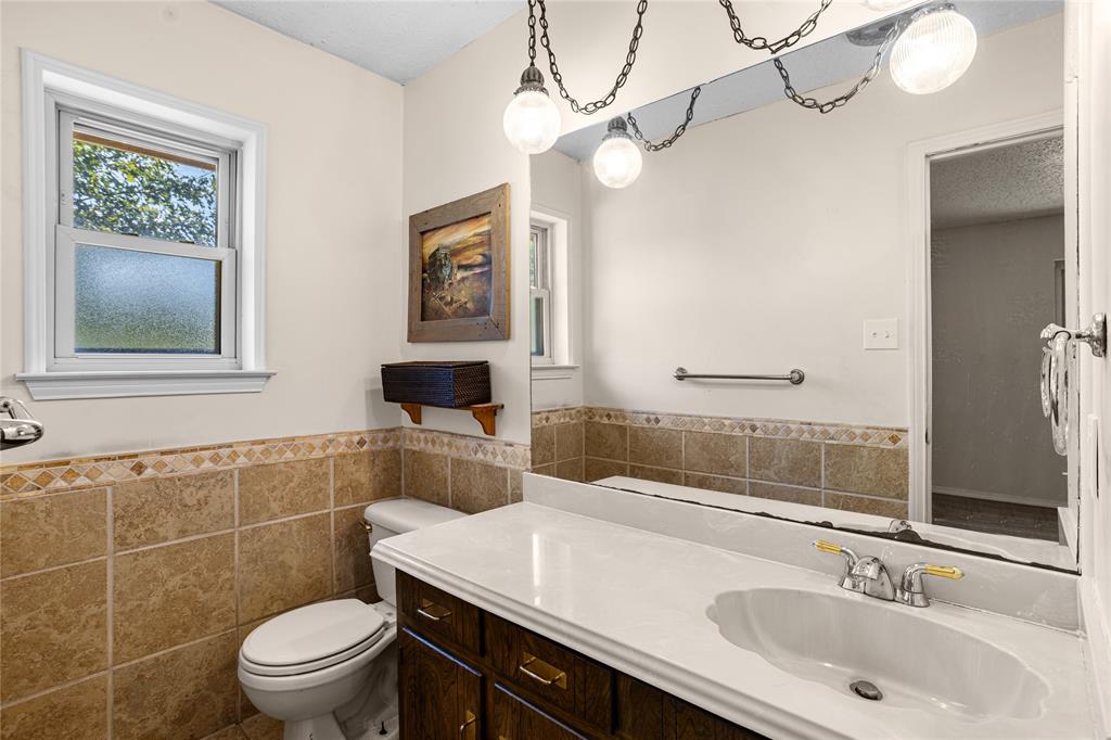 White vanity countertop with an integrated sink, polished chrome faucet, and dark wood-finish cabinetry