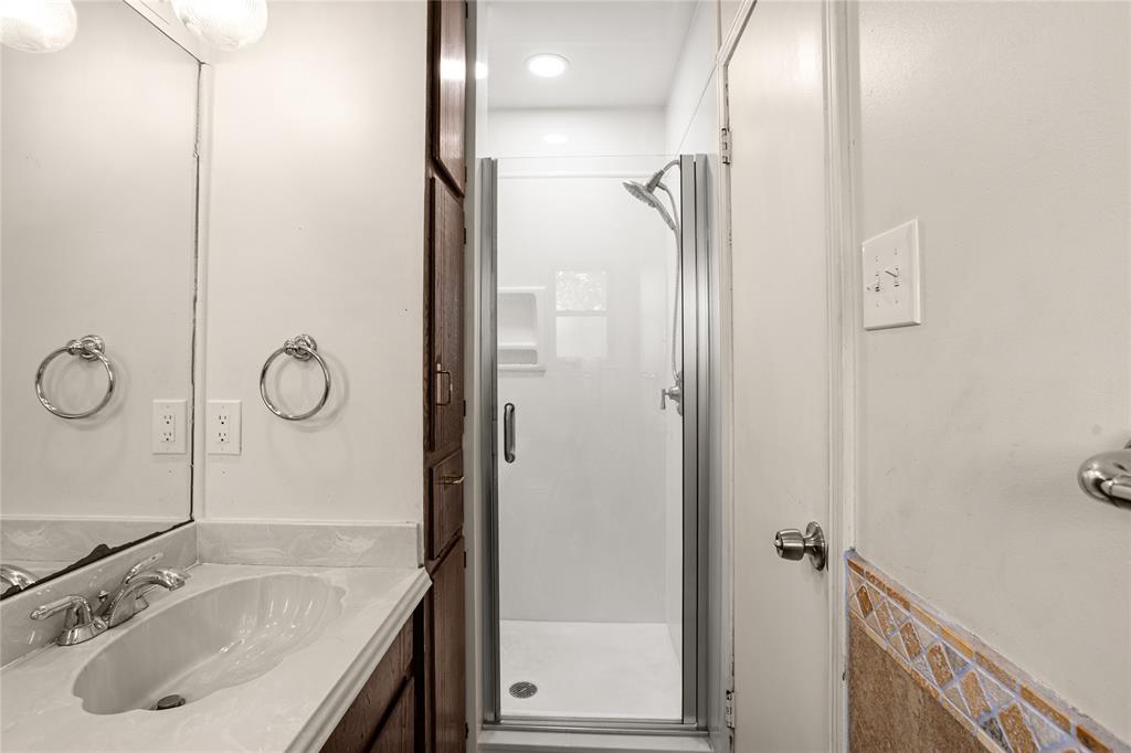 Vanity with integrated sink and chrome faucet, accompanied by a built-in wood-finish cabinet