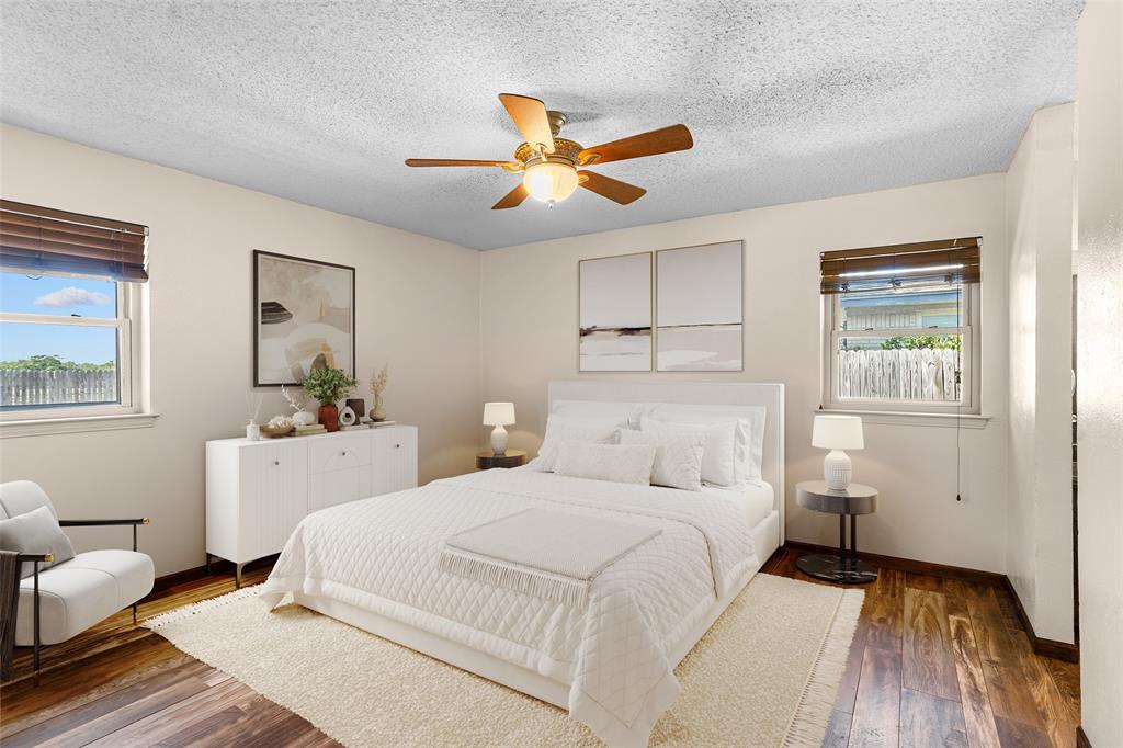 Virtually Staged Bedroom with Wood-finish flooring, ceiling fan with integrated lighting, and two windows with blinds