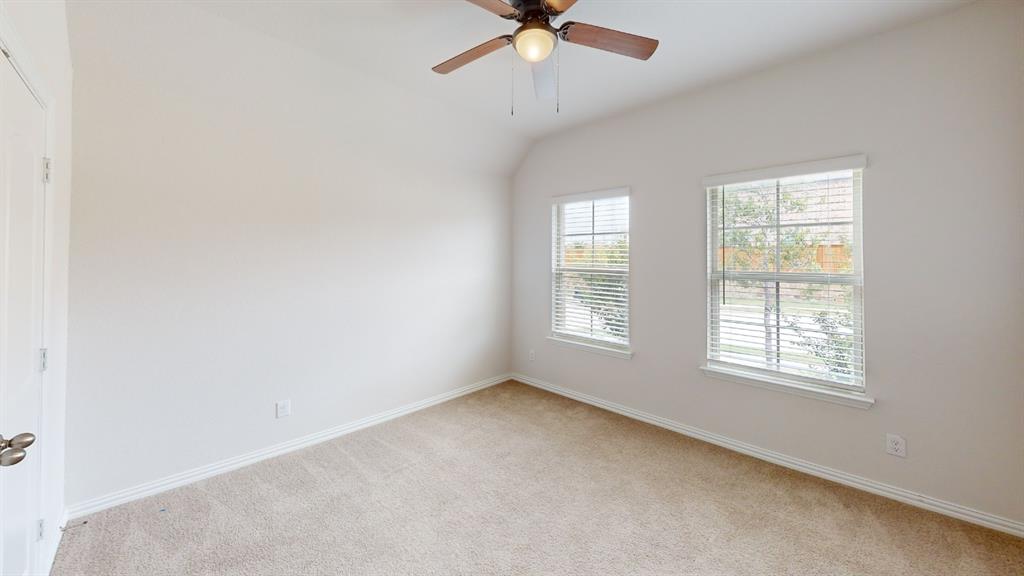 Vaulted ceiling, ceiling fan with integrated lighting, two windows with blinds, carpeted flooring, and white trim Vaulted ceiling, ceiling fan with integrated lighting, two windows with blinds, carpeted flooring, and white trim