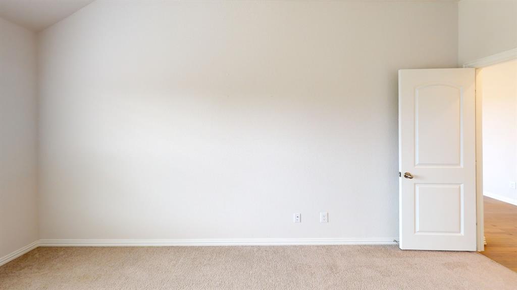 Textured wall finish, plush carpet flooring, white trim, and a white interior door