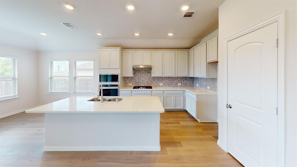 Expansive kitchen island with an undermount sink and contemporary faucet Expansive kitchen island with an undermount sink and contemporary faucet