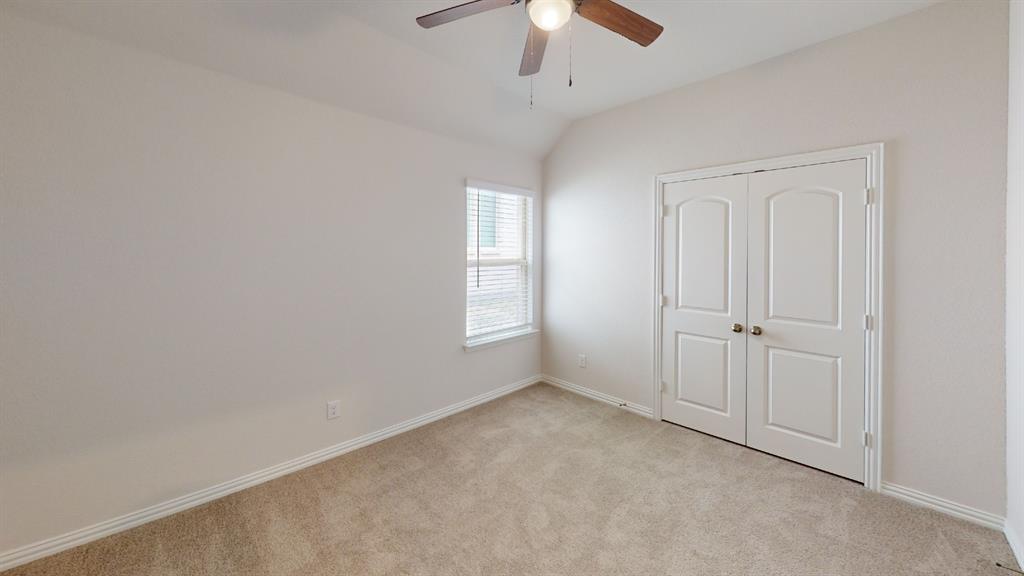 Vaulted ceiling with a wood-finish ceiling fan and attached light fixture