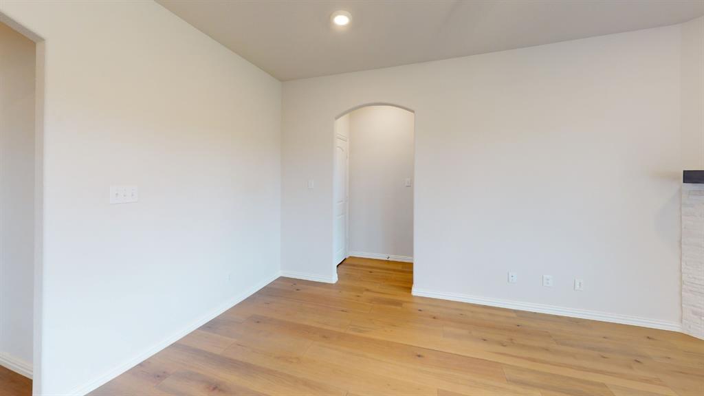 Wood-finish flooring, recessed ceiling lighting, arched doorway, and white painted walls Wood-finish flooring, recessed ceiling lighting, arched doorway, and white painted walls