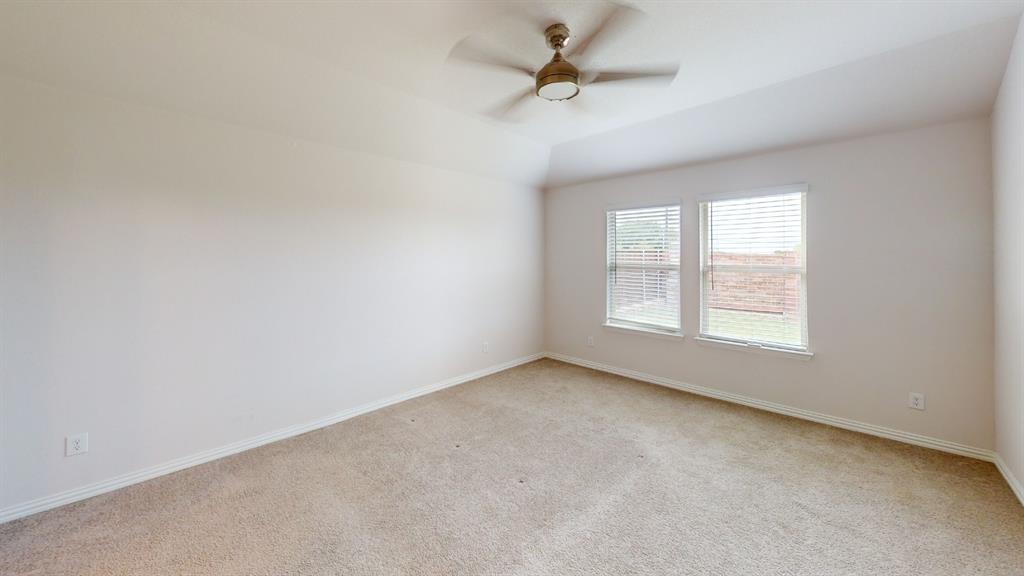 Carpeted room with a vaulted ceiling, two windows featuring blinds, and a ceiling fan Carpeted room with a vaulted ceiling, two windows featuring blinds, and a ceiling fan