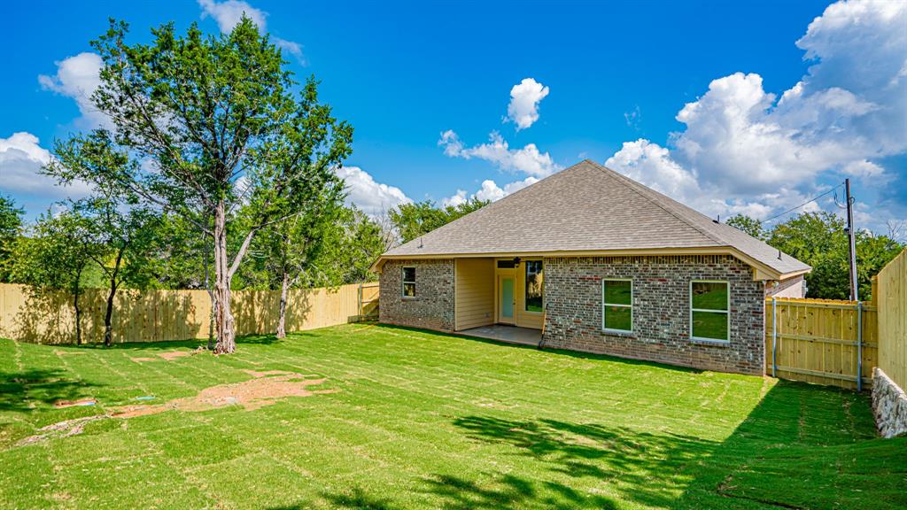Covered patio at the back of home.  Fenced and sodded yard.
