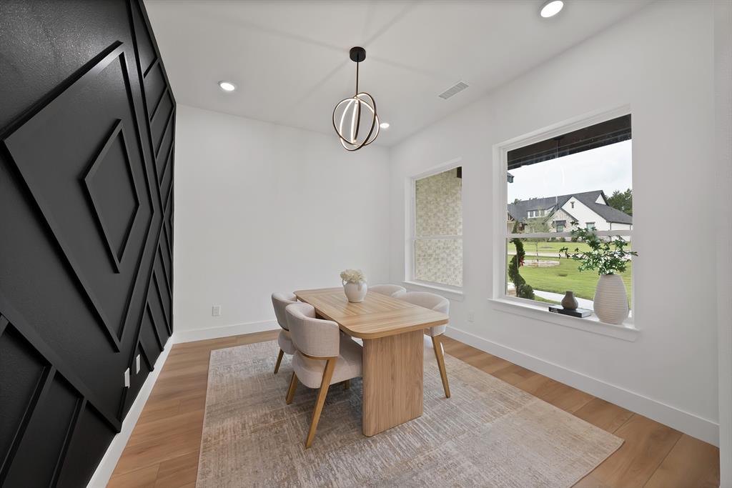 Hardwood-style flooring, sculptural accent wall, recessed lighting, contemporary chandelier, and large windows Hardwood-style flooring, sculptural accent wall, recessed lighting, contemporary chandelier, and large windows