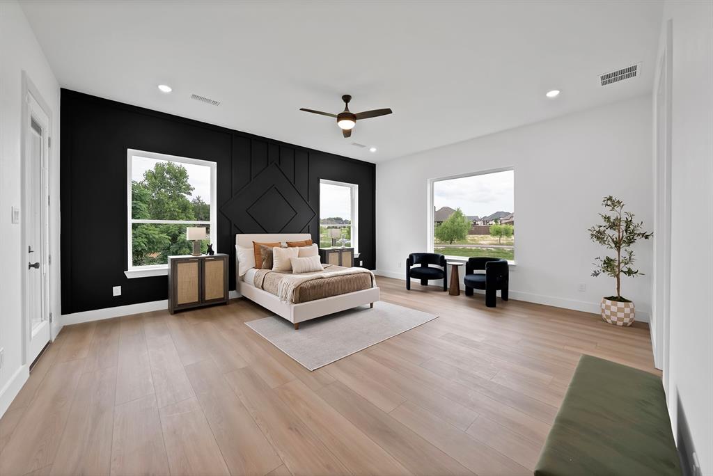 Expansive room featuring light wood-finish flooring, recessed lighting, and a ceiling fan