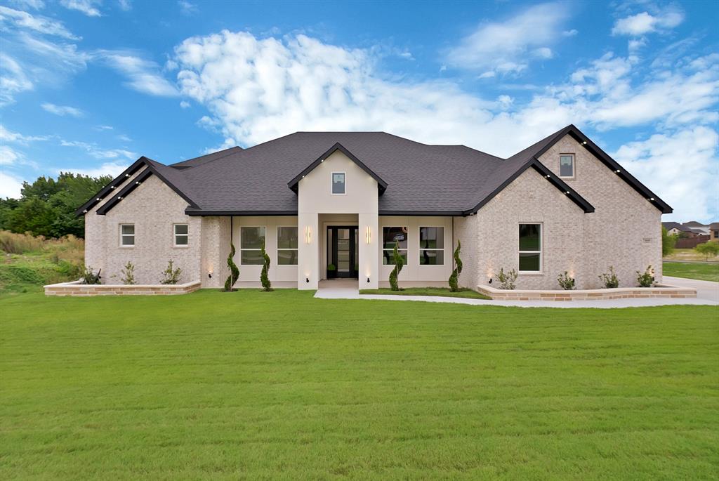 Light-colored brick and stucco exterior with dark-shingled gable roof Light-colored brick and stucco exterior with dark-shingled gable roof