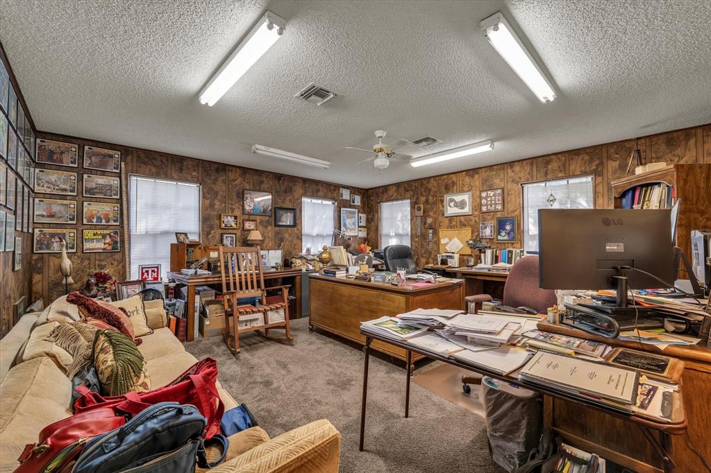 Carpeted flooring with multiple windows and wood paneling