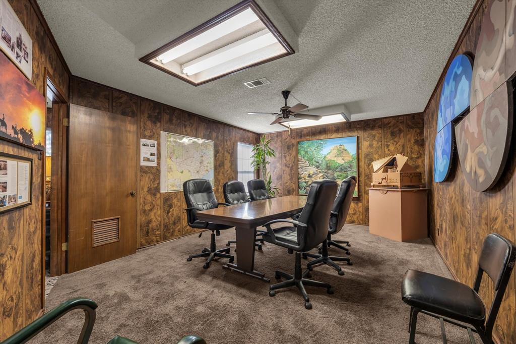 Wood-finish paneled walls with a textured ceiling and recessed lighting