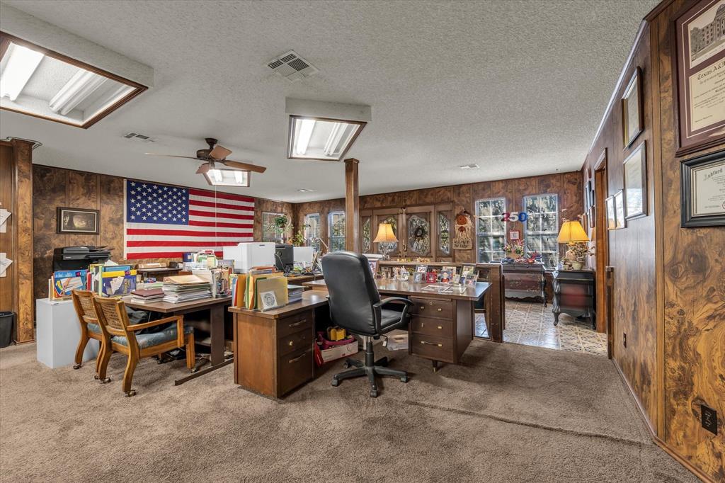 Spacious room with carpet flooring, wood paneling, recessed lighting, and a ceiling fan