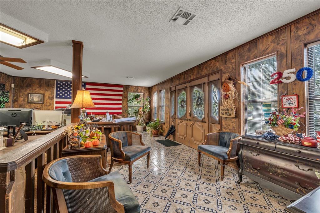 Patterned tile flooring, wood paneling, recessed lighting, ceiling fan, and French-style doors with decorative glass inserts