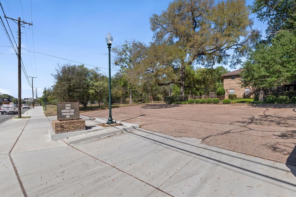 Expansive lot featuring a wide sidewalk and a street lamp