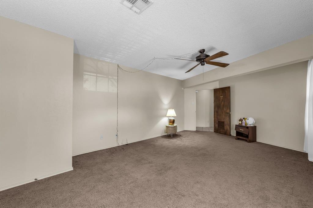 Wall-to-wall carpeting with neutral wall tones and a textured ceiling