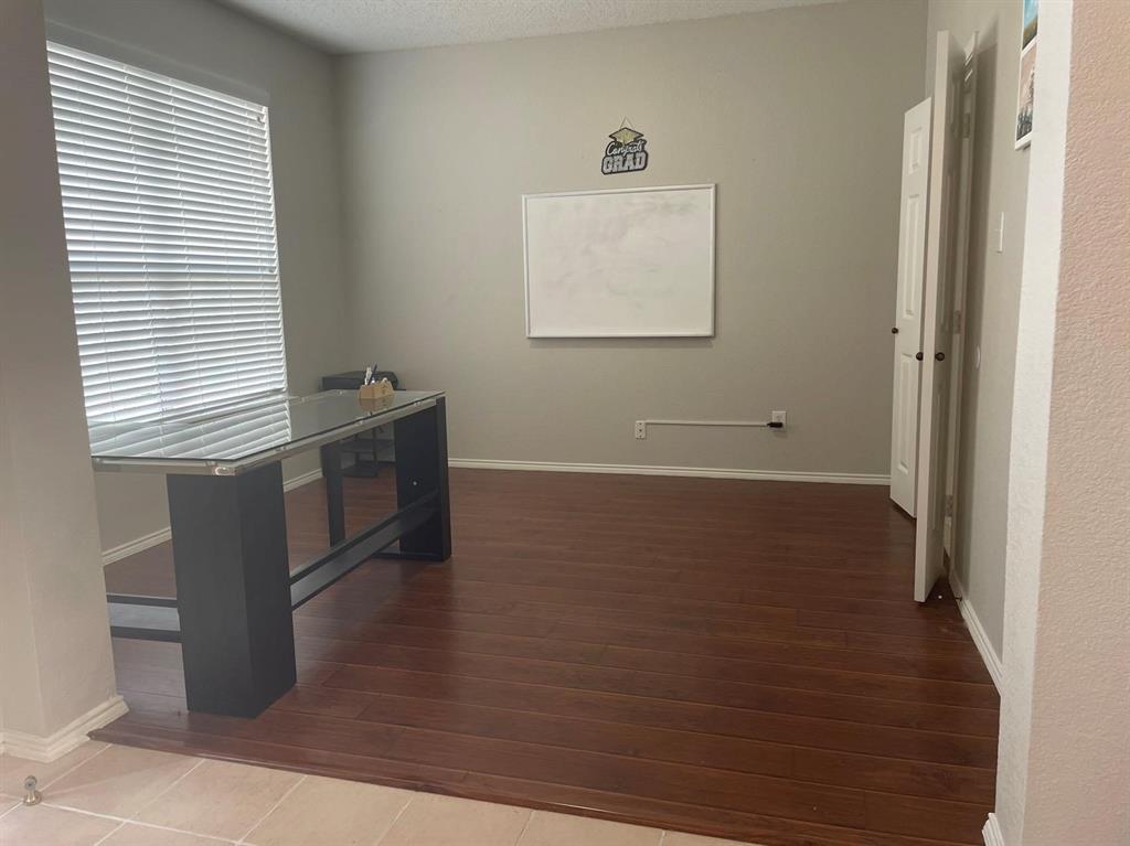 Room featuring wood-finish flooring, neutral wall paint, and horizontal window blinds