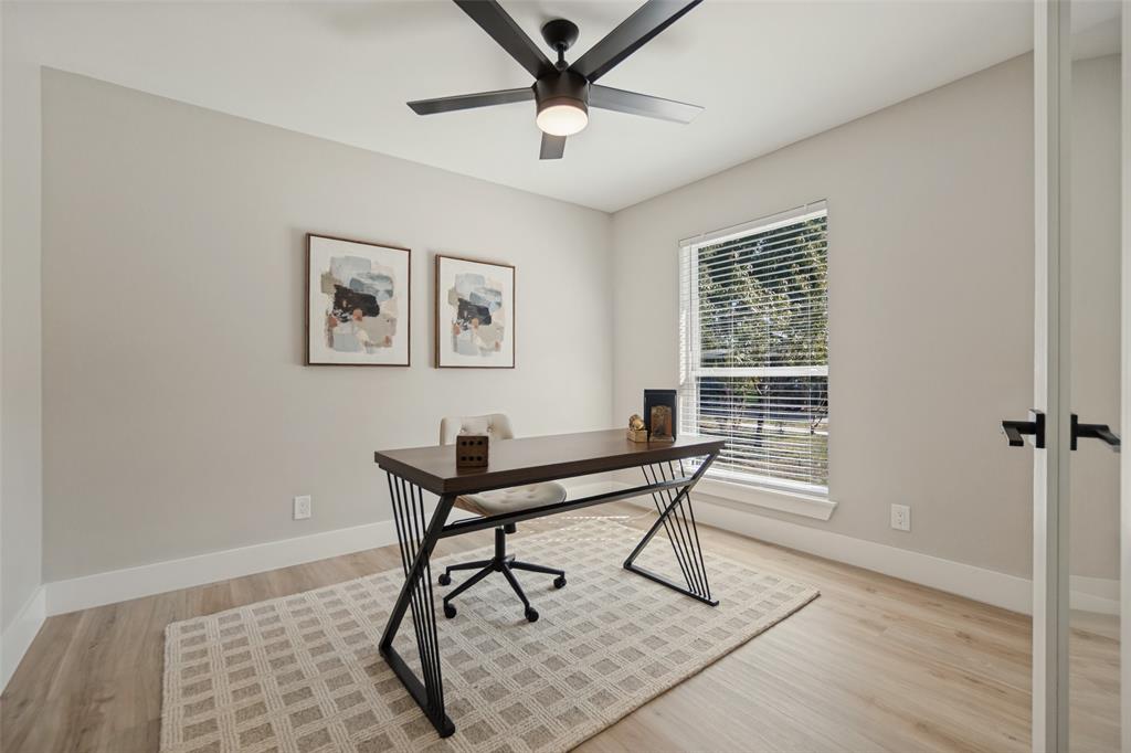Wood-finish flooring, a window with horizontal blinds, and a ceiling fan with integrated lighting