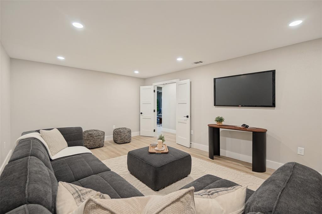 Recessed lighting illuminates neutral walls and wood-finish flooring