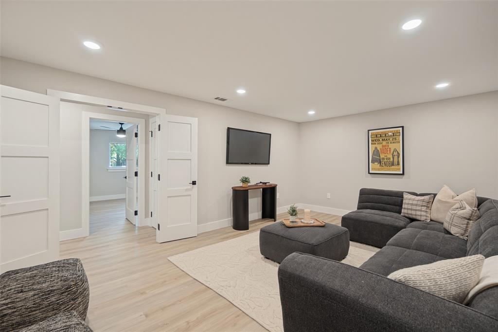 Recessed lighting, wood-finish flooring, white paneled doors, and light-toned walls