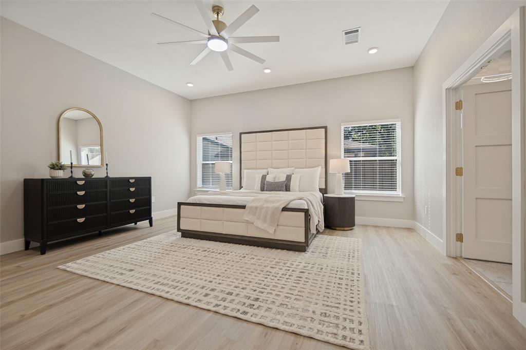 Light wood-finish flooring with recessed lighting and a ceiling fan