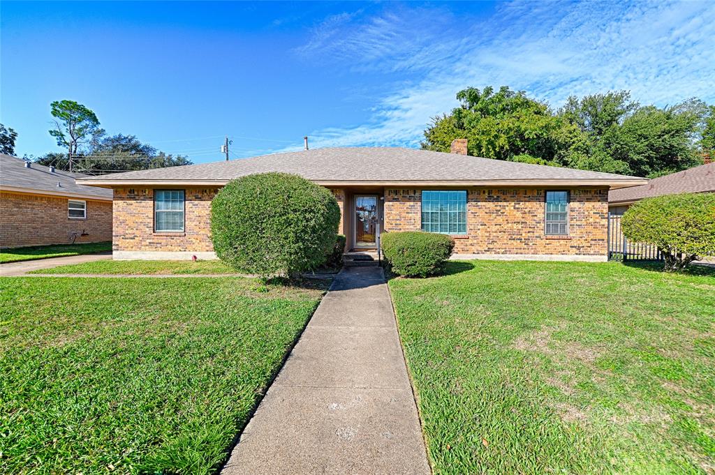 Single-story brick exterior featuring a hip roof, concrete walkway, and multi-pane windows Single-story brick exterior featuring a hip roof, concrete walkway, and multi-pane windows