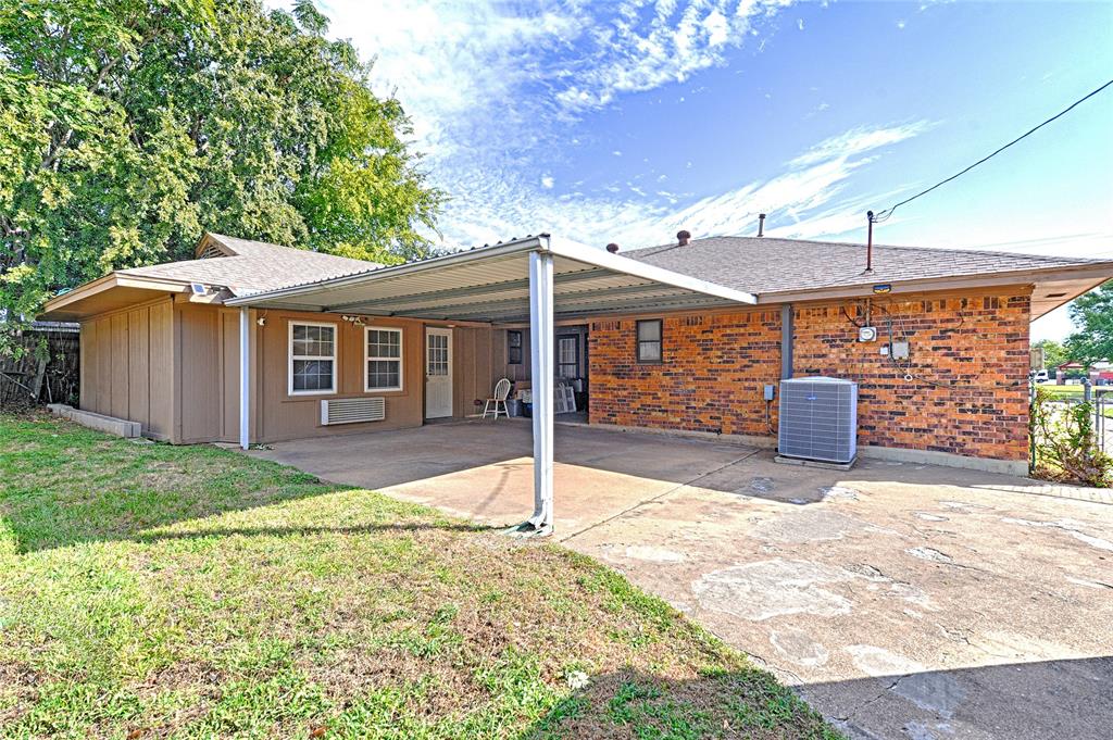 Exterior featuring a brick and composite siding facade, a covered carport with a metal roof, and concrete paving