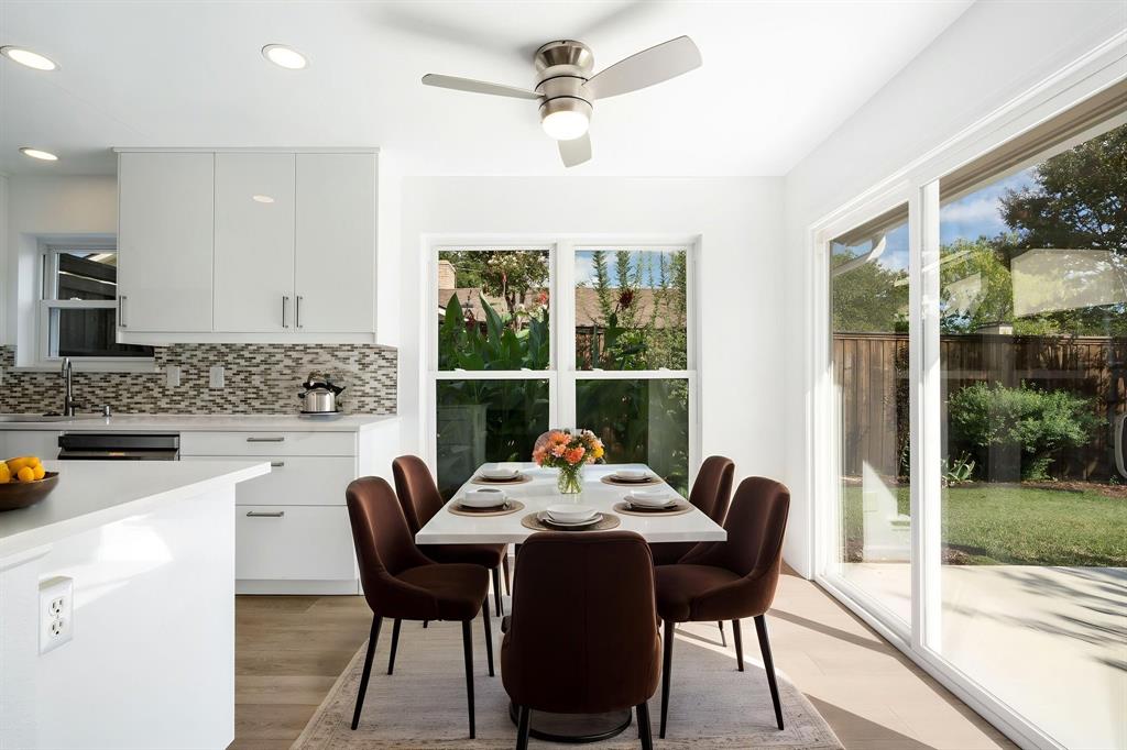 Kitchen featuring white flat-panel cabinetry, light-toned countertops, decorative tile backsplash, recessed lighting, and sliding glass doors