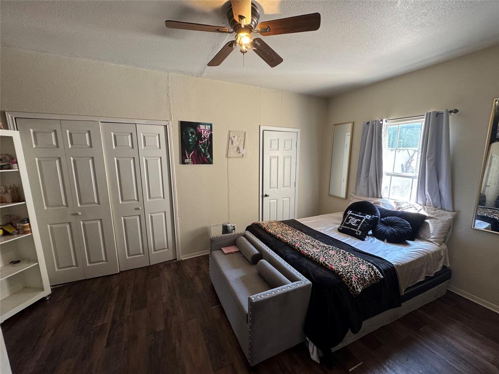 Bedroom featuring a textured ceiling, dark wood-style flooring, ceiling fan, and a closet